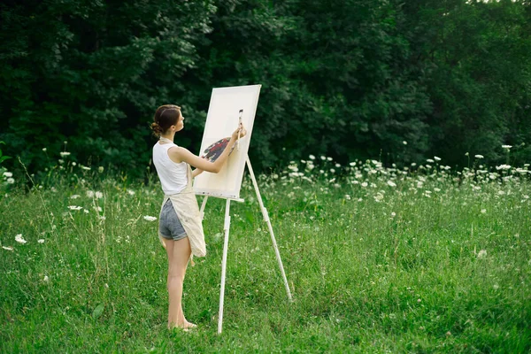 Önlüklü kadın ressam palet boyası doğayı resmediyor. — Stok fotoğraf