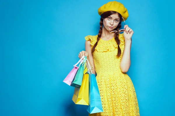 Usmívající se žena s pestrobarevnými tašky představuje izolované pozadí — Stock fotografie