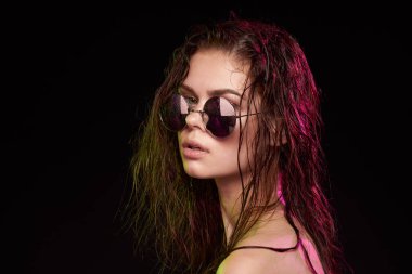 Güneş gözlüğü takan bir kadının portresi.