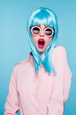 Mavi peruklu güzel kadın güneş gözlüğü takıyor.