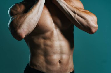 Vücudu kaslı, yeşil arka planı olan atletik bir adam.