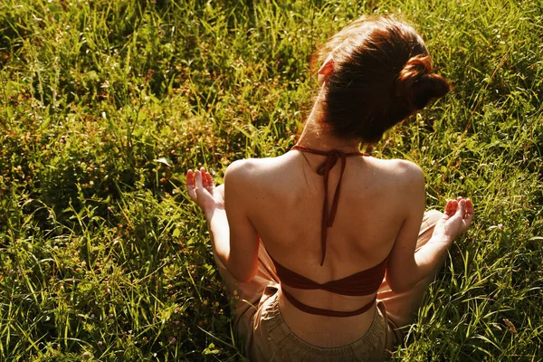 Donna nel campo seduta sull'erba meditazione riposo — Foto Stock