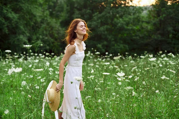 Красивая женщина в поле в белом платье на свежем воздухе — стоковое фото