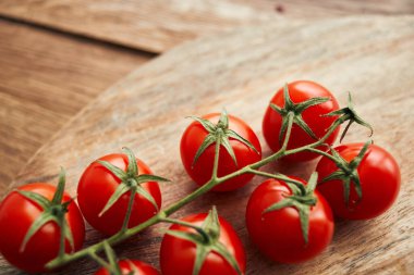 Tahta bir mutfak malzemesinin dalındaki kiraz domatesleri taze gıdalar.