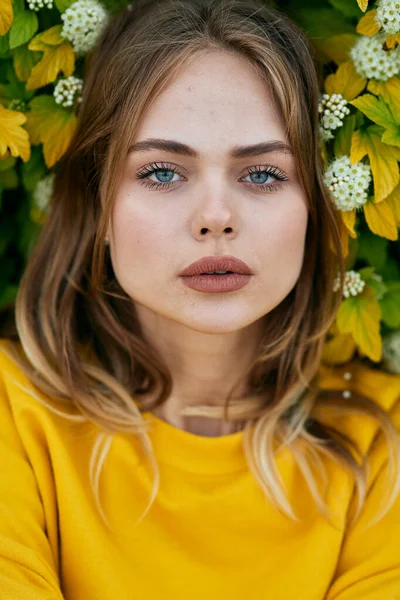 Veselá žena ve žlutém svetru květiny příroda čerstvý vzduch — Stock fotografie