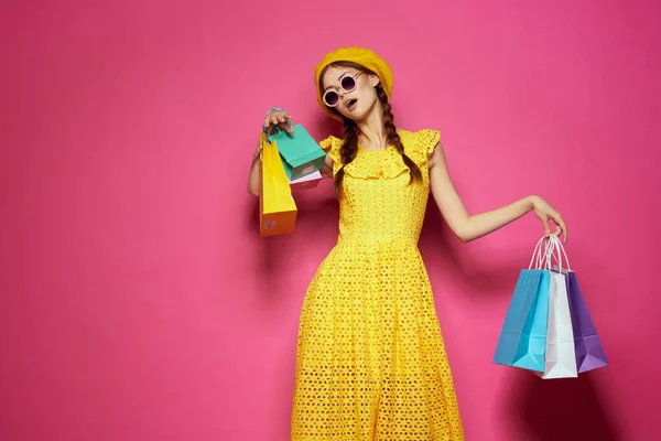 Весела жінка в жовтому капелюсі Shopaholic модний стиль рожевий фон — стокове фото
