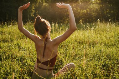Yazın çimenlerin üzerinde oturan kadın meditasyon özgürlüğü.