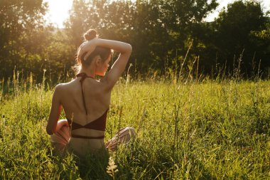 Yazın çimenlerin üzerinde oturan kadın meditasyon özgürlüğü.
