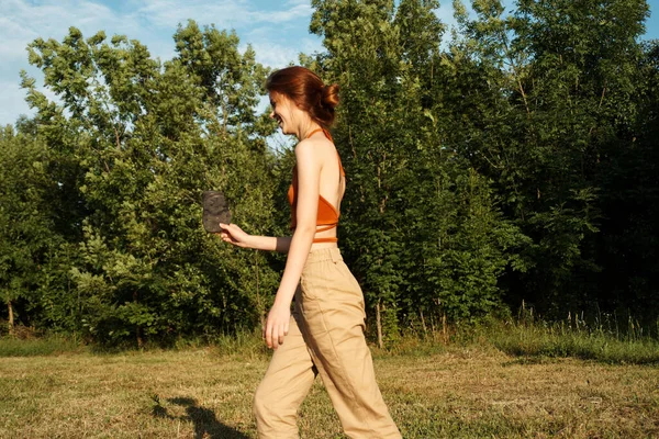 Dışarıda büyük siyah bir köpekle oynayan bir kadın. Eğlenceli bir arkadaşlık.