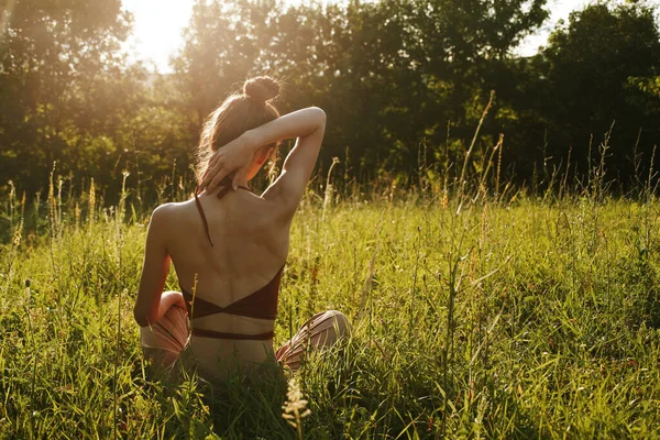 Yazın çimenlerin üzerinde oturan kadın meditasyon özgürlüğü.