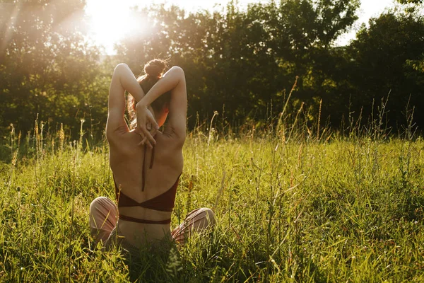 Yazın çimenlerin üzerinde oturan kadın meditasyon özgürlüğü.