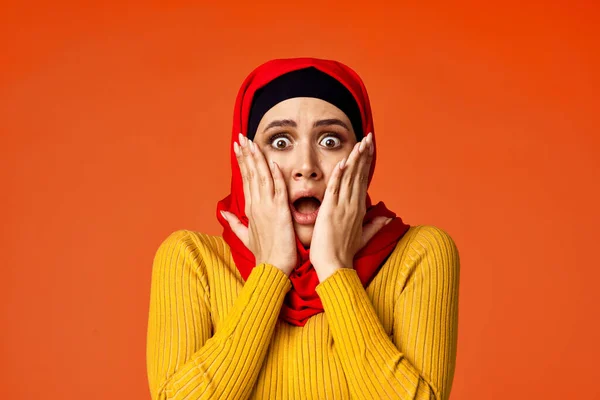 Muslimische Frau im roten Hijab posiert gestikulierend mit den Händen im Hintergrund — Stockfoto