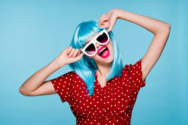 Bonita mujer moda azul peluca posando gafas de sol Imágenes de stock libres de derechos