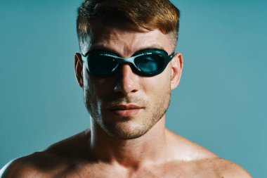 Yüzme gözlüklü adam, yüzücü mavi arka plan.