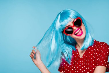 Göz kamaştırıcı mor saçlı kadın güneş gözlüğü takıyor mavi arka plan