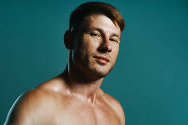 Vücudu kaslı, yeşil arka planı olan atletik bir adam.