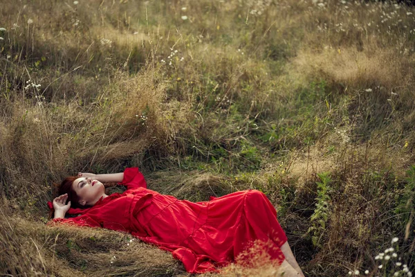 Woman in a black dress lies in a field nature fashion summer — Stock Photo, Image