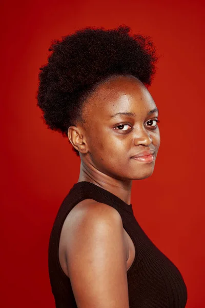 黑色T恤红色背景的卷曲非洲女人 — 图库照片