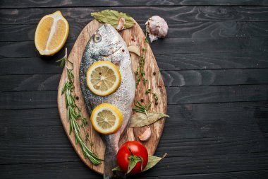 Tahta üzerinde balık. Malzemeler limon taze deniz ürünleri.