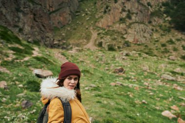 Sırt çantalı kadın yürüyüşçü dağlarda yolculuk özgürlüğü.