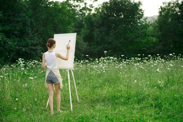 Önlüklü kadın ressam palet boyası doğayı resmediyor. — Stok fotoğraf