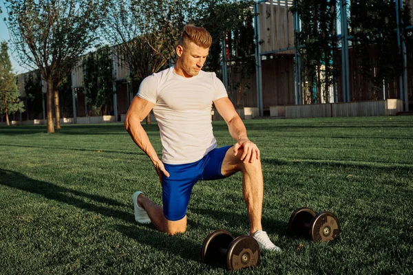 Parktaki adam yeşil çimen egzersiz egzersizi yapıyor.