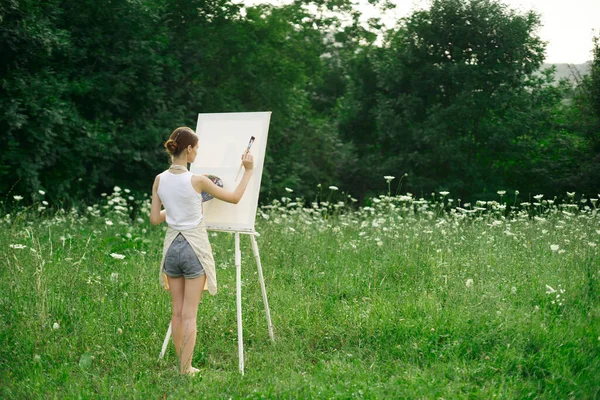 Vrouw kunstenaar in schorten verf palet ezel natuur — Stockfoto