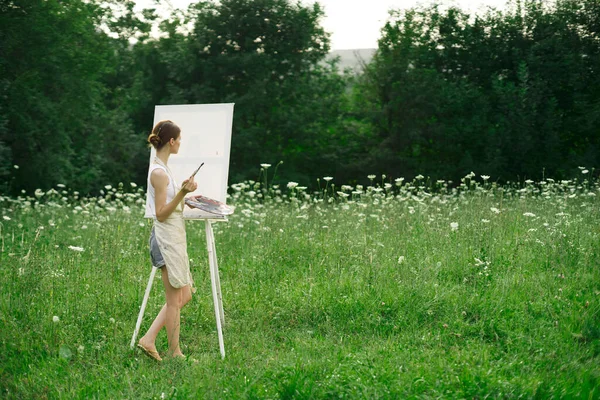 Kvinna konstnär i förkläden måla palett staffli natur — Stockfoto