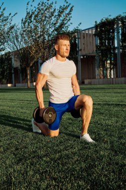 Parktaki adam yeşil çimen egzersiz egzersizi yapıyor.