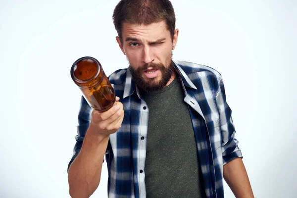 Een man in een geruit shirt bier alcohol emoties leuk licht achtergrond — Stockfoto