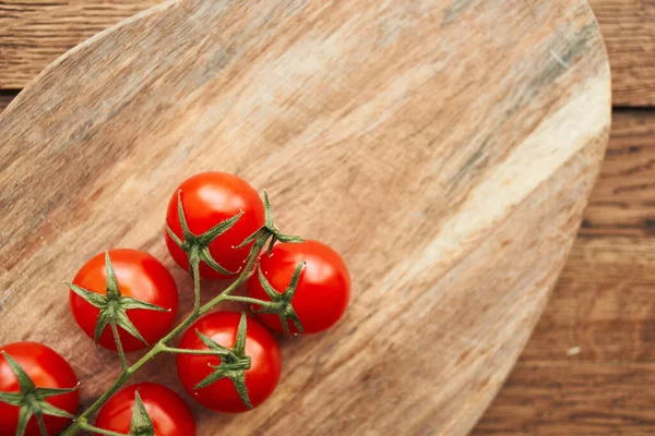 Tahta bir mutfak malzemesinin dalındaki kiraz domatesleri taze gıdalar.