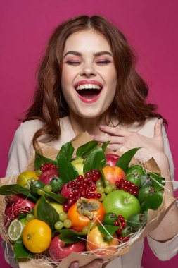 Güzel kadın gülümsüyor taze meyve buketi duyguları sergiliyor pembe arka plan