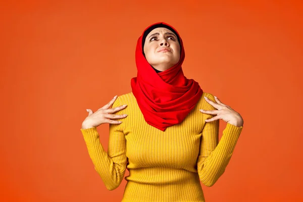 Muslimische Frau im roten Hijab posiert gestikulierend mit den Händen im Hintergrund — Stockfoto