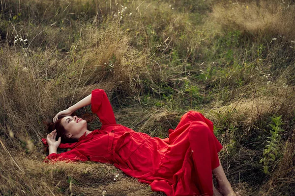 穿着黑色连衣裙的女人躺在田野里，自然是夏天的时尚 — 图库照片