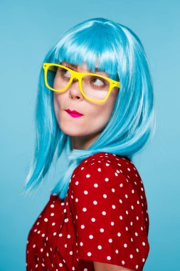 Mavi peruklu, sarı gözlüklü, çekici bir kadın.