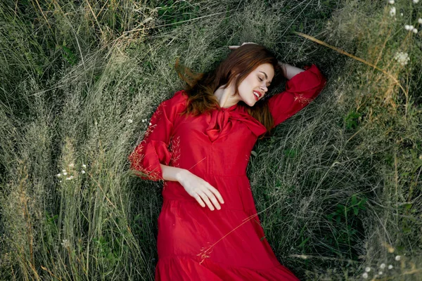 Kırmızı elbiseli kadın doğa yeşil çimen manzarası — Stok fotoğraf