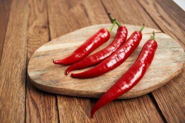 Ahşap mutfak malzemelerinin üzerinde kırmızı kırmızı kırmızı biber.