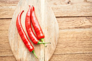 Ahşap mutfak malzemelerinin üzerinde kırmızı kırmızı kırmızı biber.