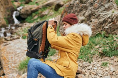 Sırt çantalı kadın yürüyüşçü dağlarda yolculuk özgürlüğü.