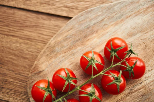 Tomates cherry en una rama en un ingrediente de cocina de tablero de madera alimentos frescos —  Fotos de Stock