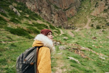 Sırt çantalı kadın yürüyüşçü dağlarda yolculuk özgürlüğü.