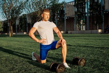 Parktaki adam yeşil çimen egzersiz egzersizi yapıyor.