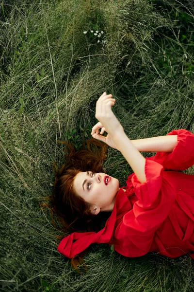 Woman in red dress lies on the grass fresh air nature freedom — Stock Photo, Image