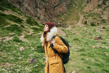 Sırt çantalı kadın yürüyüşçü dağlarda yolculuk özgürlüğü.