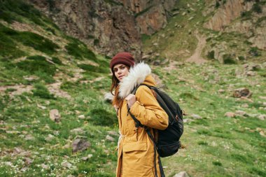 Sırt çantalı kadın yürüyüşçü dağlarda yolculuk özgürlüğü.