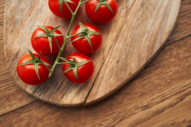 Tahta bir mutfak malzemesinin dalındaki kiraz domatesleri taze gıdalar.