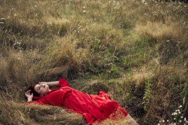 Siyah elbiseli kadın yaz mevsiminde doğa modasında yatıyor.
