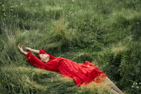 Woman in a black dress lies in a field nature fashion summer — Stock Photo, Image
