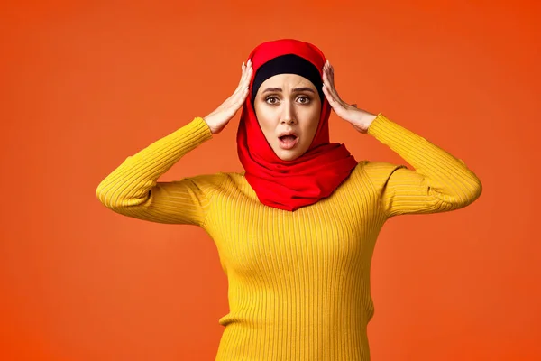 Muslimische Frau im roten Hijab posiert gestikulierend mit den Händen im Hintergrund — Stockfoto