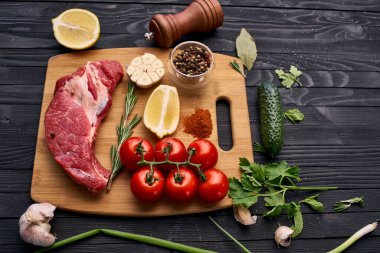 Tahta bir bifteğin üzerindeki et sebzeleri.